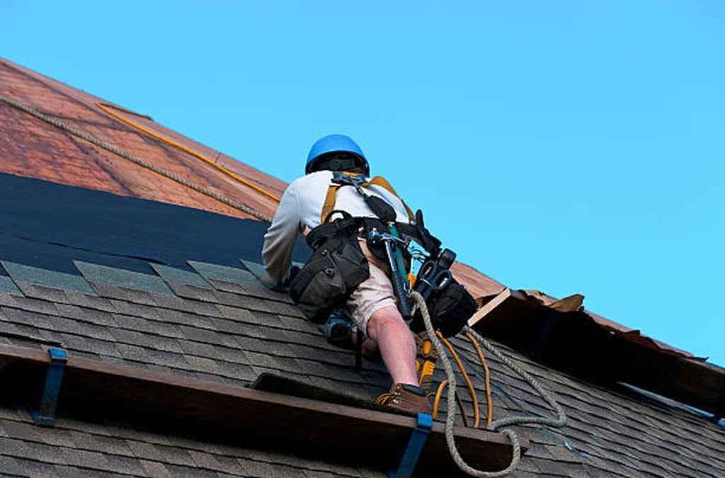 roofing contractor with hard helmet and harness